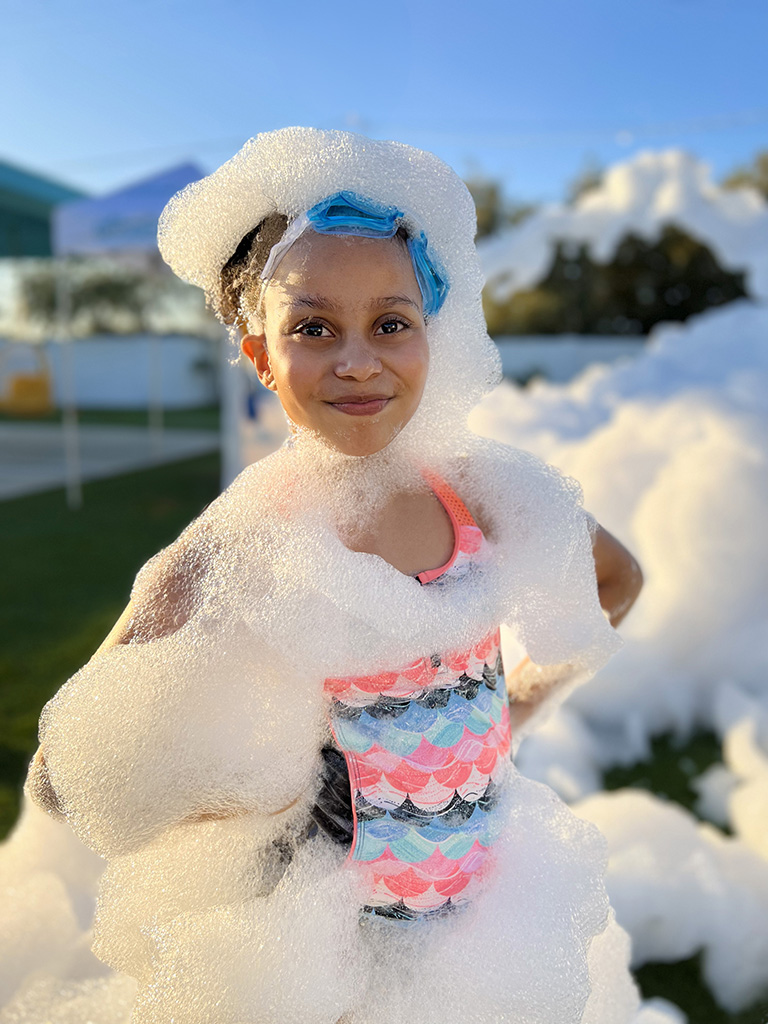 Child smiling covered in foam