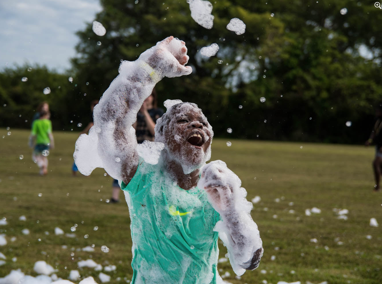 Child throwing foam in the air on a field